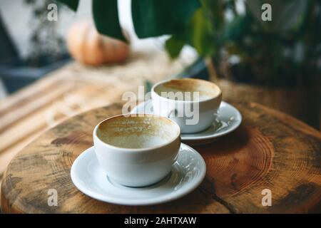 Zwei leeren Becher nach dem Trinken von Kaffee auf einem Holztisch. Konzept für die Beendigung einer Sitzung oder etwas anderes. Stockfoto