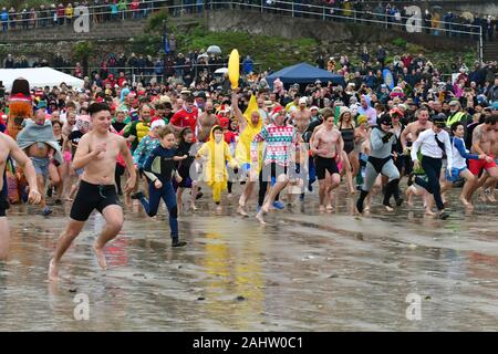 Dorset UK. 01 Jan, 2020. Hunderte von Menschen, die sich der neuen Jahre Tag Schwimmen mit allen die Teilnahme an Fancy Dress am Strand von Lyme Regis in Dorset zu beobachten. Foto: Robert Timoney/Alamy leben Nachrichten Stockfoto