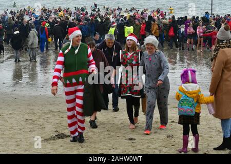 Dorset UK. 01 Jan, 2020. Hunderte von Menschen, die sich der neuen Jahre Tag Schwimmen mit allen die Teilnahme an Fancy Dress am Strand von Lyme Regis in Dorset zu beobachten. Foto: Robert Timoney/Alamy leben Nachrichten Stockfoto