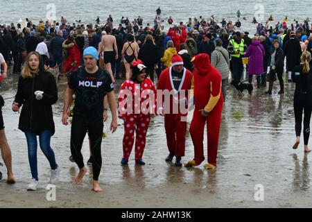 Dorset UK. 01 Jan, 2020. Hunderte von Menschen, die sich der neuen Jahre Tag Schwimmen mit allen die Teilnahme an Fancy Dress am Strand von Lyme Regis in Dorset zu beobachten. Foto: Robert Timoney/Alamy leben Nachrichten Stockfoto