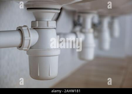 In der Nähe von weißen Kunststoff Rohr entleeren Unter waschen Waschbecken im Badezimmer. Stockfoto