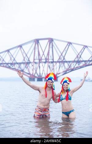 South Queensferry, Edinburgh, Schottland. 1. Jan 2020.. Jecken trotzen der kalten Wasser für den traditionellen Tag der neuen Jahre Loony Dook mit den ikonischen Forth Bridge im Hintergrund Credit: Richard Newton/Alamy leben Nachrichten Stockfoto