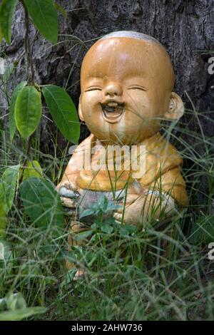 Die Figur der fröhliche junge im Garten von buddhistischen Kloster. Stockfoto