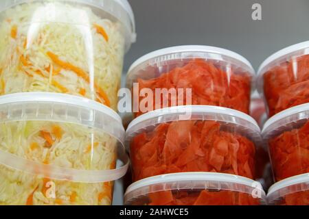 Dosen, marinierte fermentiert und eingelegtes Gemüse in Kunststoff Gläser. Sauerkraut, saure Gurken, eingelegten Ingwer in den Supermarkt. Stockfoto