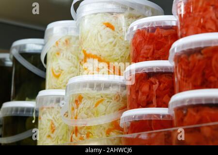 Dosen, marinierte fermentiert und eingelegtes Gemüse in Kunststoff Gläser. Sauerkraut, saure Gurken, eingelegten Ingwer in den Supermarkt. Stockfoto