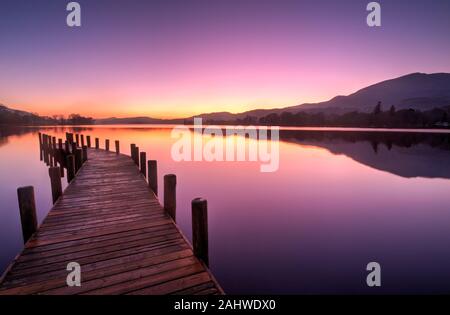 Anlegesteg am Coniston Water, der gegen den letzten Sonnenuntergang 2019 nach Süden blickt Stockfoto