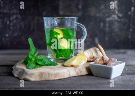 Frische Minze - Ingwer Tee mit Minze, Ingwer Birne und Rock Zucker auf Holz Stockfoto