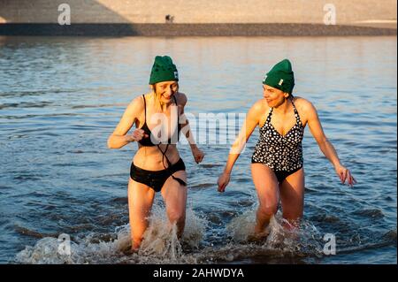 Nijmegen, Niederlande. 1 Jan, 2020. Frauen tragen grüne Hüte aus dem kalten Wasser. Das Klima Tauchen ist eine Variante des Tauchgangs die jährliche Neues Jahr. Hunderte von Menschen ging für ein erfrischendes Bad in den Strand von Spiegelwaal in der niederländischen Stadt Nijmegen. In diesem Jahr wurde durch die unabhängige Umweltorganisation Milieudefensie organisiert. Diese Organisation hielt mehrere 'Klima' Tauchgänge rund um das Land, die niederländische Regierung, dass das Klima im Jahr 2020 ernste zu zeigen. Credit: Ana Fernandez/SOPA Images/ZUMA Draht/Alamy leben Nachrichten Stockfoto