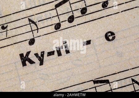 Gedruckte Wort Kyrie auf alten handgeschöpftem Papier mit Noten Stockfoto