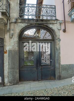 Alte farbige Holztür mit schmiedeeisernen Verzierungen, braucht Wartung Stockfoto