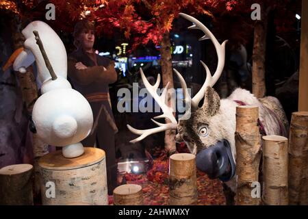 London, Großbritannien - 20 Dezember 2019, Käufer Stellen gegenüber der Anzeige an den Disney Store auf der Oxford Street. Stockfoto