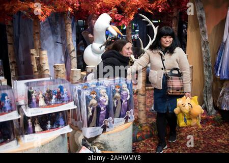 London, Großbritannien - 20 Dezember 2019, Käufer Stellen gegenüber der Anzeige an den Disney Store auf der Oxford Street. Stockfoto