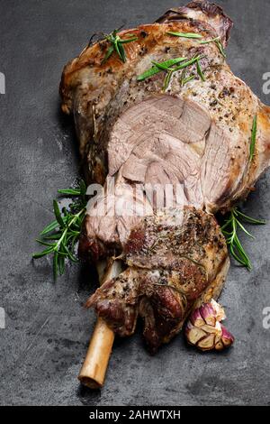 Ganze Lammbraten Bein auf dem schwarzen Stein Hintergrund Stockfoto