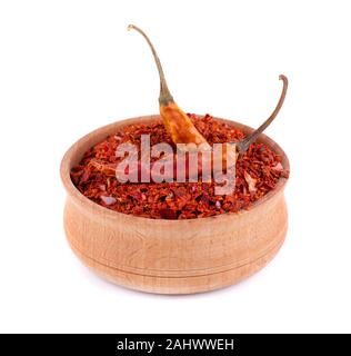 Trocken und gemahlen Chili Flocken auf weißem Hintergrund. Red chili Pfeffer in die hölzerne Schüssel. Stockfoto