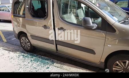 Gebrochene hintere Seitenscheibe eines Autos durch Dieb mit Glasscherben auf dem Boden. Auto Dieb, Versicherung, Alarm Schutzkonzepte Stockfoto