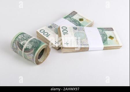 Roll und Stapel des polnischen Zloty auf weißem Hintergrund. Republik Polen Währung Stockfoto