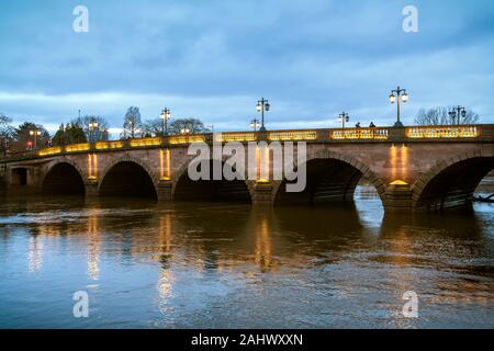Worcester Brücke in der Abenddämmerung. Traditionelle Laternen Licht die herrliche Bögen der Brücke und in das Wasser des Flusses Severn unten reflektieren. Stockfoto