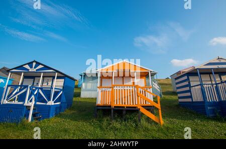 Mehrfarbige Urlaub hölzernen Umkleidekabinen am Strand mit Blick auf das Meer am Strand von tankerton Whitstable, Kent District England. Stockfoto