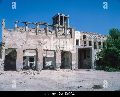 Szenen des Alten Dubai mit den verlassenen baufälligen Ruinen der Shindagha Dorf auf dem Dubai Seite an der Mündung des Dubai Creek, wie er in der Mitte der 1980er Jahre. Der gesamte Bereich wurde im Jahr 1990 renoviert der Dubai Heritage Village, das ist jetzt ein beliebtes Touristenziel. Die websites Bedeutung, wie hier zu sehen von den Obersten Büros und Majlis ist die Heimat der Palast des Herrschers und Büros von Emir Scheich Juma Al Maktoum war und später sein Sohn Sheikh Saeed Bin Juma Al Maktoum. Stockfoto