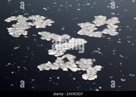 Salzkristalle, die auf der Wasseroberfläche eines Sinkholes, Toten Meer, schweben. Das Meer hat die niedrigste Erhebung der Erde. Stockfoto