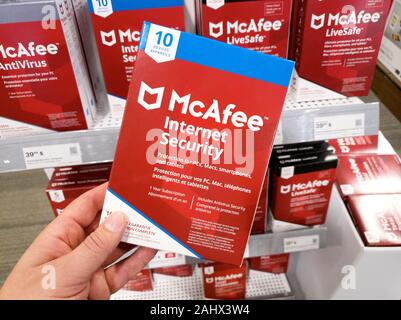 Montreal, Kanada - Dezember 26, 2019: eine Hand, die McAfee Internet Security Box mit Lizenz und Programm. McAfee ist eine US-amerikanische Global computer Secu Stockfoto