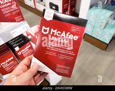 Montreal, Kanada - Dezember 26, 2019: eine Hand, die McAfee Livesafe Box mit Lizenz und Programm. McAfee ist eine US-amerikanische global Computer Security soft Stockfoto