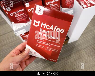 Montreal, Kanada - Dezember 26, 2019: eine Hand, die McAfee Total Protection Box mit Lizenz und Programm. McAfee ist eine US-amerikanische global Computer secur Stockfoto