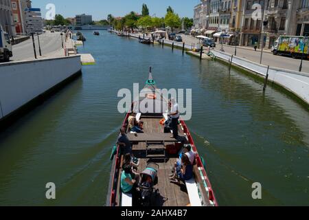 Touristen genießen Sie eine Bootsfahrt auf einem traditionellen Moliceiro Kanal Boot auf dem zentralen Kanal in Aveiro Portugal Stockfoto