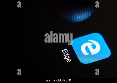 Edge Browser App-Symbol auf dem Smartphone-Bildschirm und Finger starten Sie es. Stockfoto