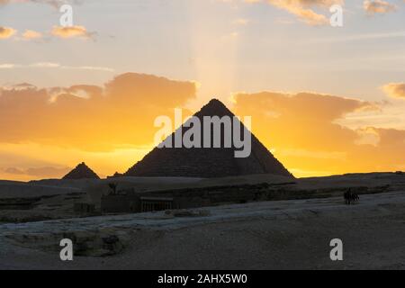 Sonnenuntergang in Gizeh Pyramide komplex. Die Sonne geht hinter die Pyramide des Menkaure. Stockfoto