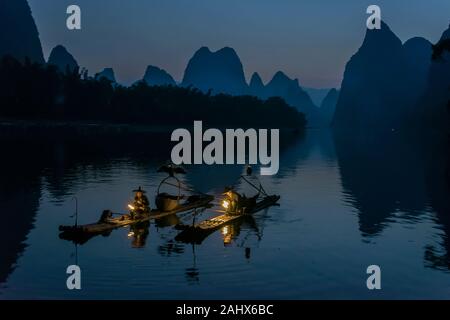 Zwei kormorante Fischer, die am frühen Morgen ihre Laternen beleuchten, Li River, Xingping, Guilin, China Stockfoto