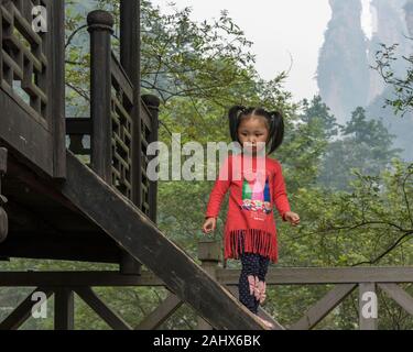 Süßes junges Mädchen in einem farbenfrohen Outfit in der Nähe von Golden Whip Stream, Zhangiajie National Park, Hunnan, China Stockfoto