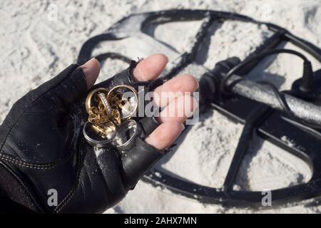 Metall detectorist hält Schmuck von Metalldetektor am Strand in Florida gefunden. Stockfoto