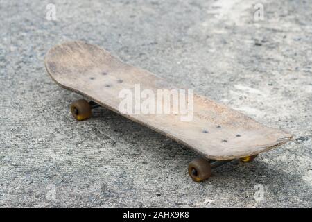 Alte hölzerne Skateboard auf dem Zement Straße Stockfoto