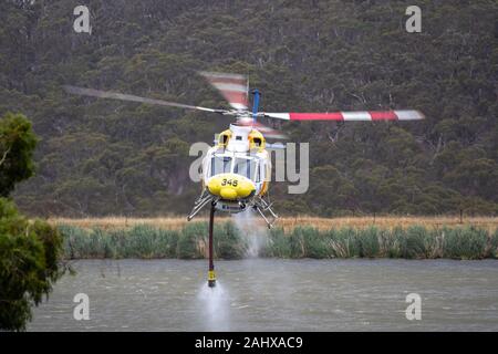 Bell 412 Hubschrauber, die nach dem Befüllen mit einer Belastung von Wasser ein Feuer zu bekämpfen. Stockfoto