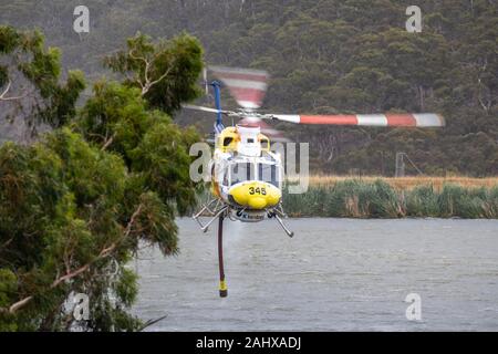 Bell 412 Hubschrauber, die nach dem Befüllen mit einer Belastung von Wasser ein Feuer zu bekämpfen. Stockfoto