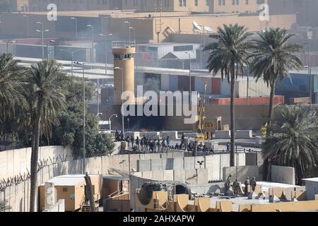 Bagdad, Irak. 01. Januar, 2020. Gruppen von gewalttätigen Demonstranten aus dem Iran - Kataib Hisbollah-miliz gesichert konfrontieren die irakischen Sicherheitskräfte vor der US-Botschaft am 1. Januar 2020 in Bagdad, Irak. Credit: Maj. Charlie Dietz/Planetpix/Alamy leben Nachrichten Stockfoto