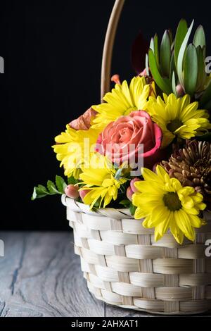 Herbst Blumenstrauß mit Lilien und Gänseblümchen auf Holzboden und schwarzen Hintergrund. Erntefest auf Thanksgiving. Stockfoto