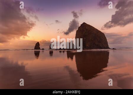 Der Haystack Rock in Oregon am Cannon Beach bei Sonnenuntergang Stockfoto