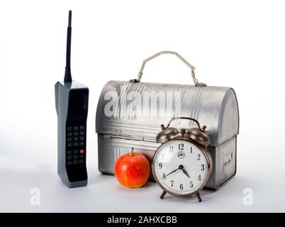 Arbeitszeit in den 1980er Jahren mit Ziegel Handy Lunchpaket und roten Apfel. Stockfoto