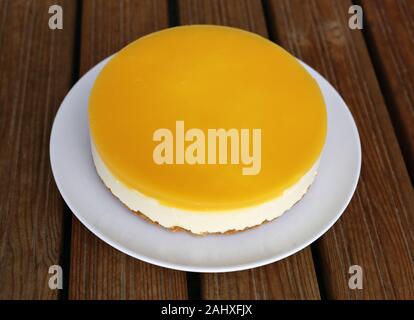 Glutenfrei vegan orange und Mango Cheesecake mit vegan Agar Agar Pulver. Hausgemachte Kuchen mit cookie Base, mango Käse Mousse, orange Layer. Stockfoto