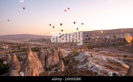 Goreme, Kappadokien, Türkei. Wunderschöne Szenen im Goreme Nationalpark. Hunderte von bunten Heißluftballons fliegen am Himmel bei Sonnenaufgang. Stockfoto