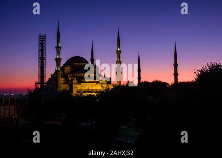 Blaue Moschee, Sultan Ahmed Moschee Sultan Ahmet Camii, mit einem Minarett von Gerüsten, nach Sonnenuntergang beleuchtet umgeben Stockfoto