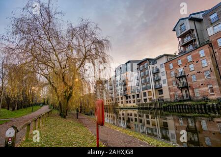 Pfad am Fluss Wensum in der Stadt Norwich und die teure Waterside Apartments und Penthäuser Stockfoto