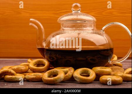 Bagels und ein Glas Tee Wasserkocher auf einem hölzernen Hintergrund Stockfoto