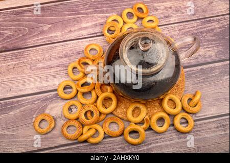 Bagels und ein Glas Tee Wasserkocher auf einem hölzernen Hintergrund. Der Blick von oben Stockfoto