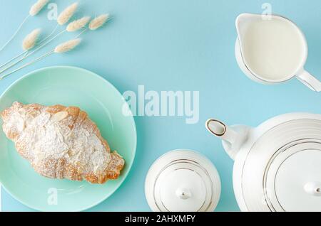 Morgen Tabelle. Frische Croissants auf Türkis Platten und Milch auf Pastell-blaue Hintergrund. Ansicht von oben, kopieren. Stockfoto