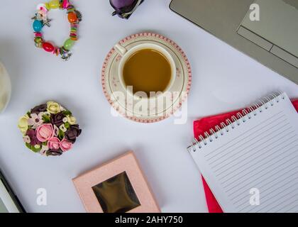 Kaffee im Büro, in der Nähe des Schreibtisch mit verschiedenen Objekten, schön gestalteten Tasse mit heißem Getränk, Business Konzept Stockfoto
