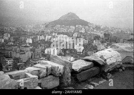 Touristentour durch die Ruinen des alten antiken Olympia, mit Blick auf den Lykabettus und der Stadt Athen, Griechenland 1950er. Touristische Tour durch die Ruinen des antiken Olympia mit Blick auf den Lycabettus und die Stadt Athen, Griechenland 1950. Stockfoto