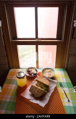 Picknick an der Ferryland Leuchtturm in Neufundland und Labrador, Kanada. Das Mittagessen mit einem Sandwich, Getränk, Salat, Teegebäck und Clotted cre Stockfoto